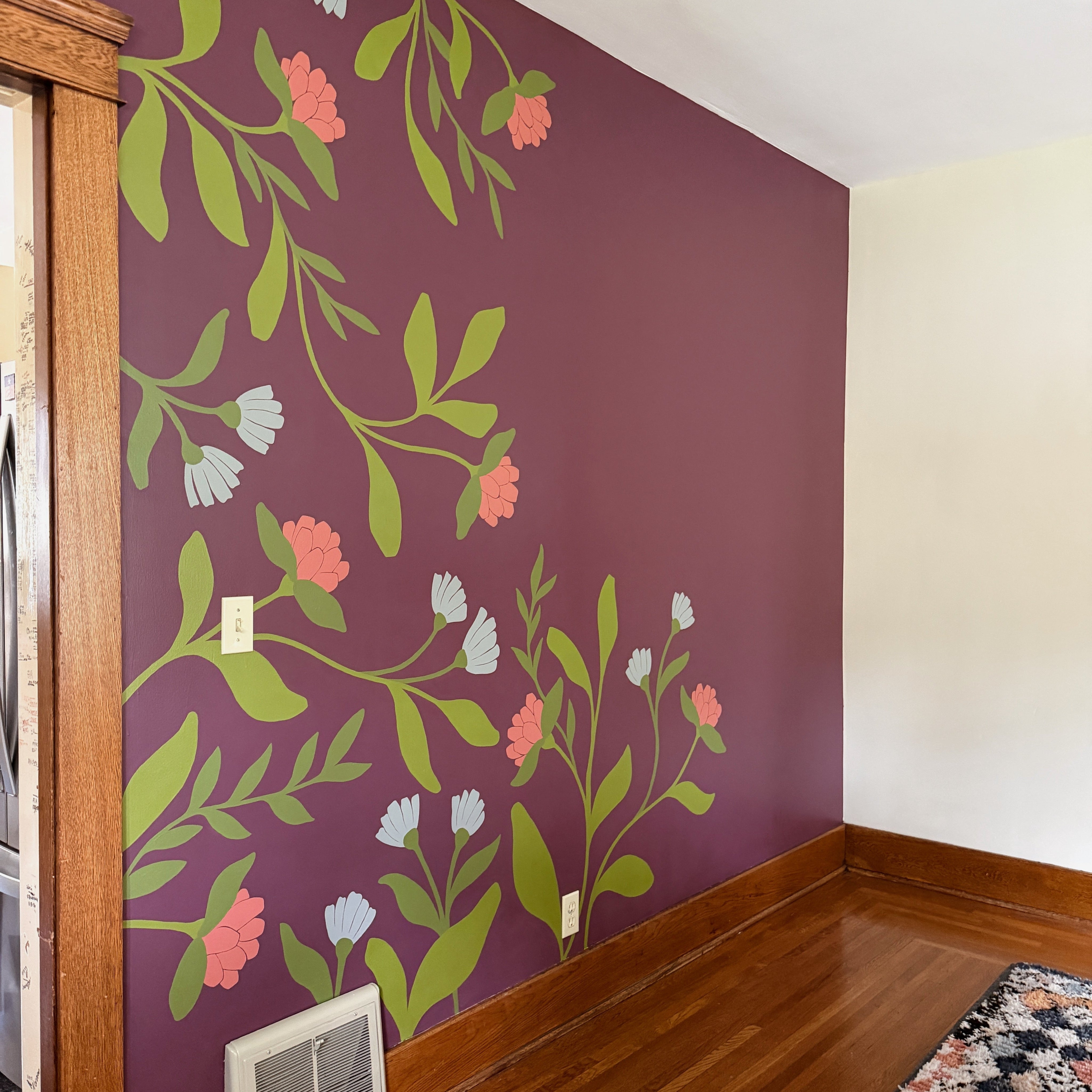 A finished floral and botanical mural painted on a dining room wall in a home.
