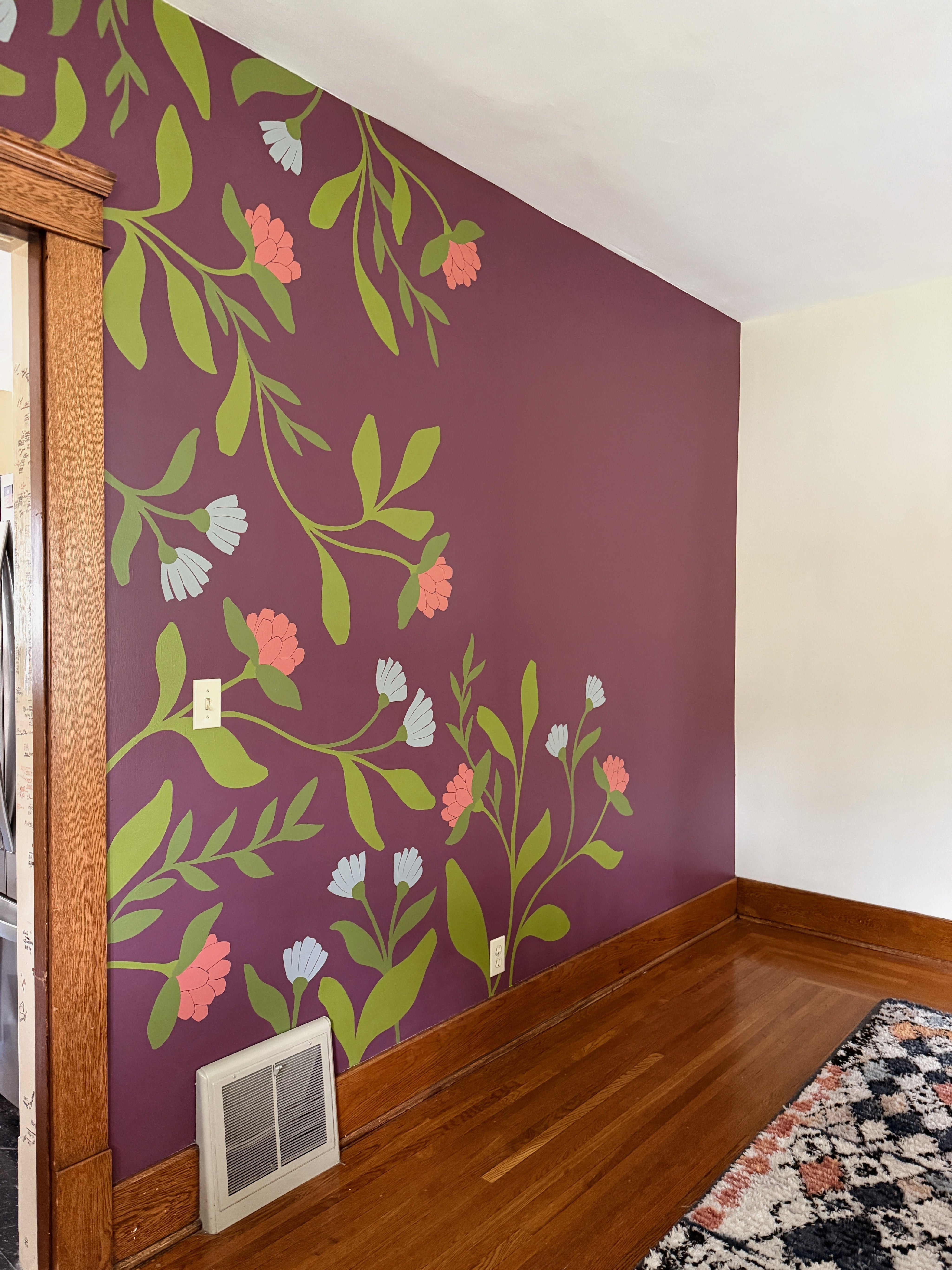 A finished floral and botanical mural painted on a dining room wall in a home.