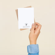 Back of the Congrats to a Perfect Pair greeting card and envelope held in hand
