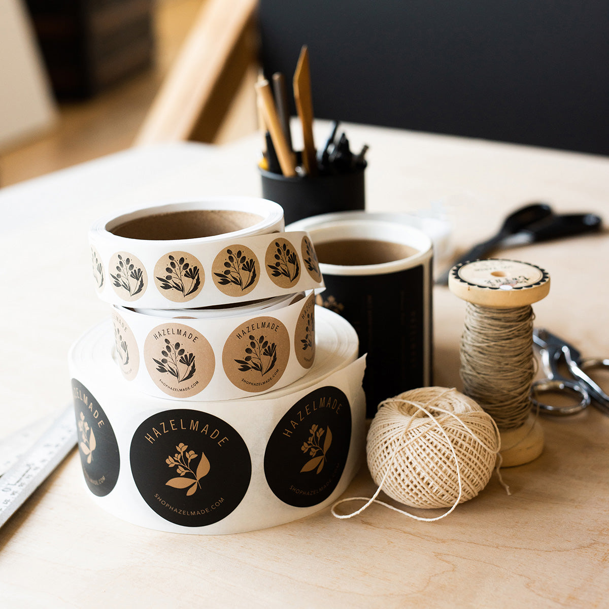 Hazelmade custom packaging labels and wrapping materials arranged on a desk