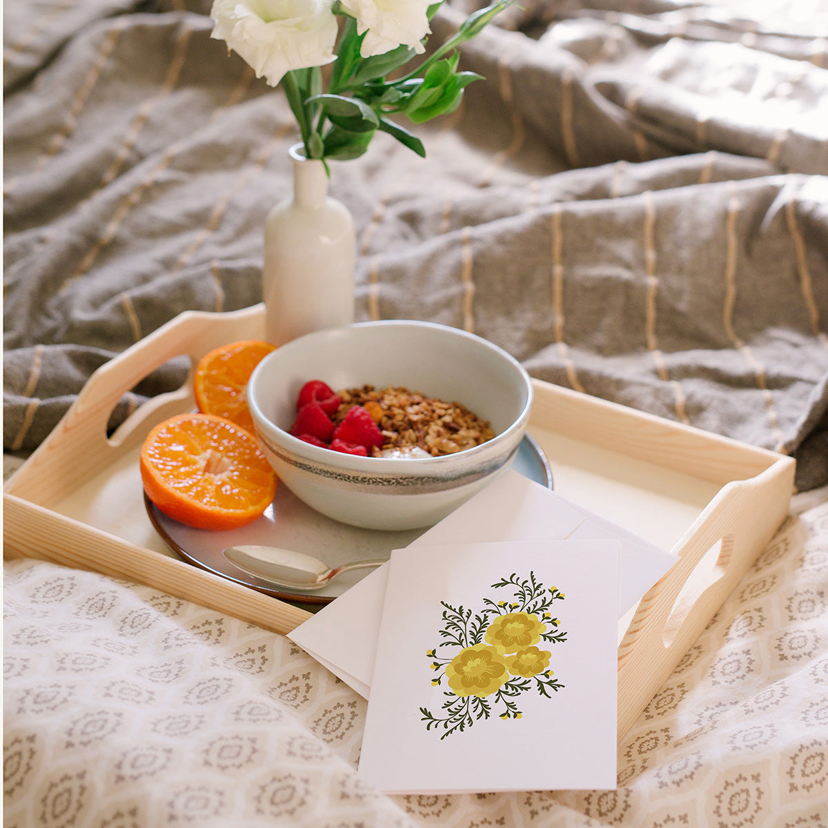 Hazelmade floral greeting cards styled on a breakfast tray with fruit, flowers, and granola