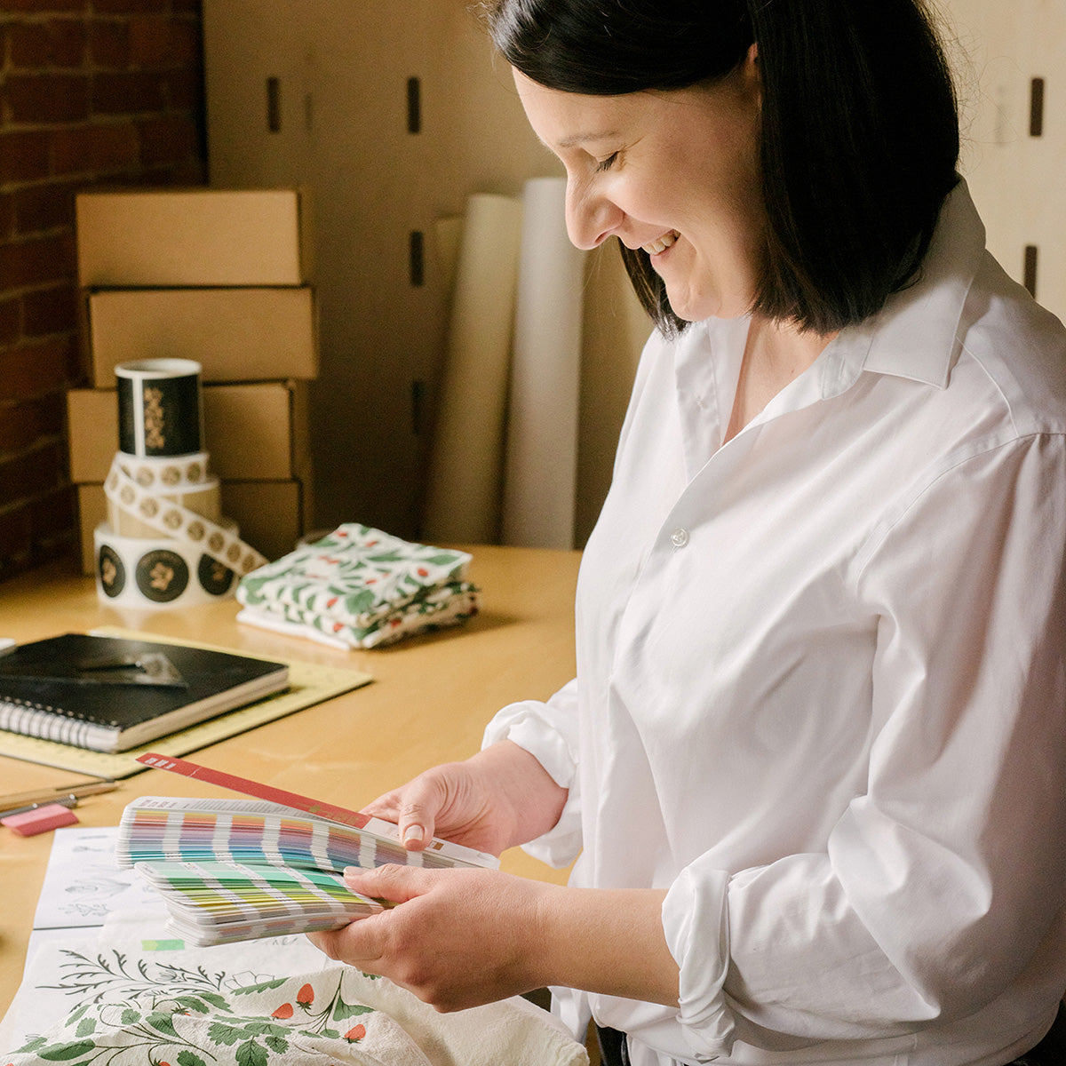 Susan Hazel Rich reviewing color swatches and custom design materials at her desk