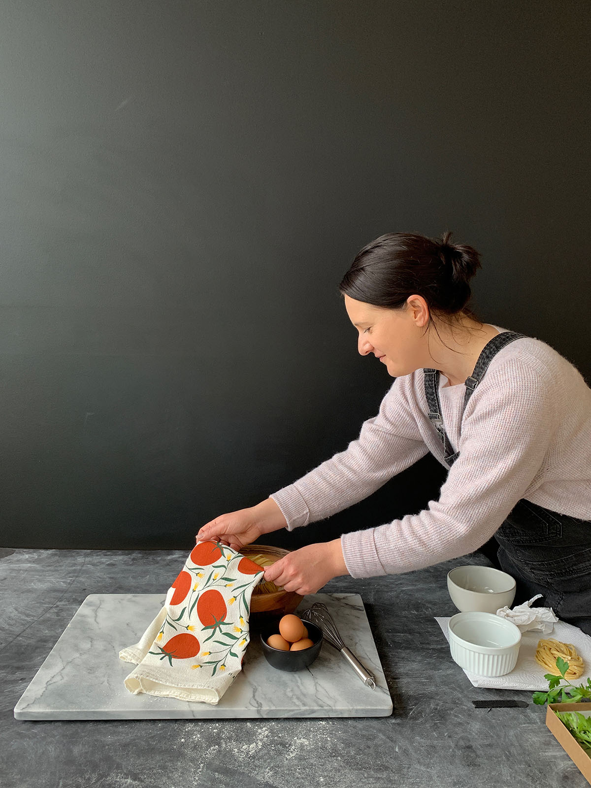 Susan Hazel Rich styling a tomato-patterned Hazelmade tea towel during a product photoshoot