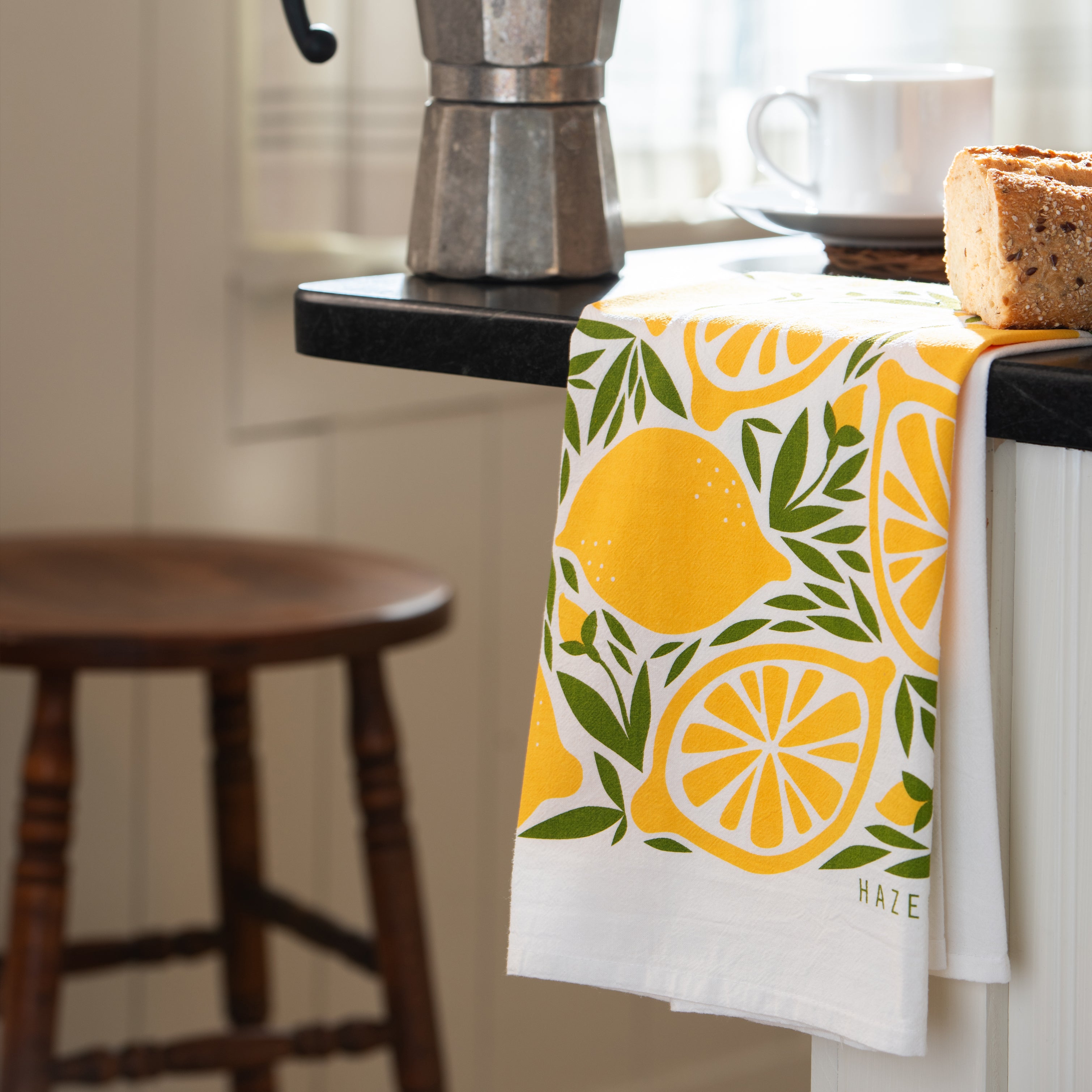 Lemon Tea Towel hanging beside a moka coffee maker and bread in a kitchen