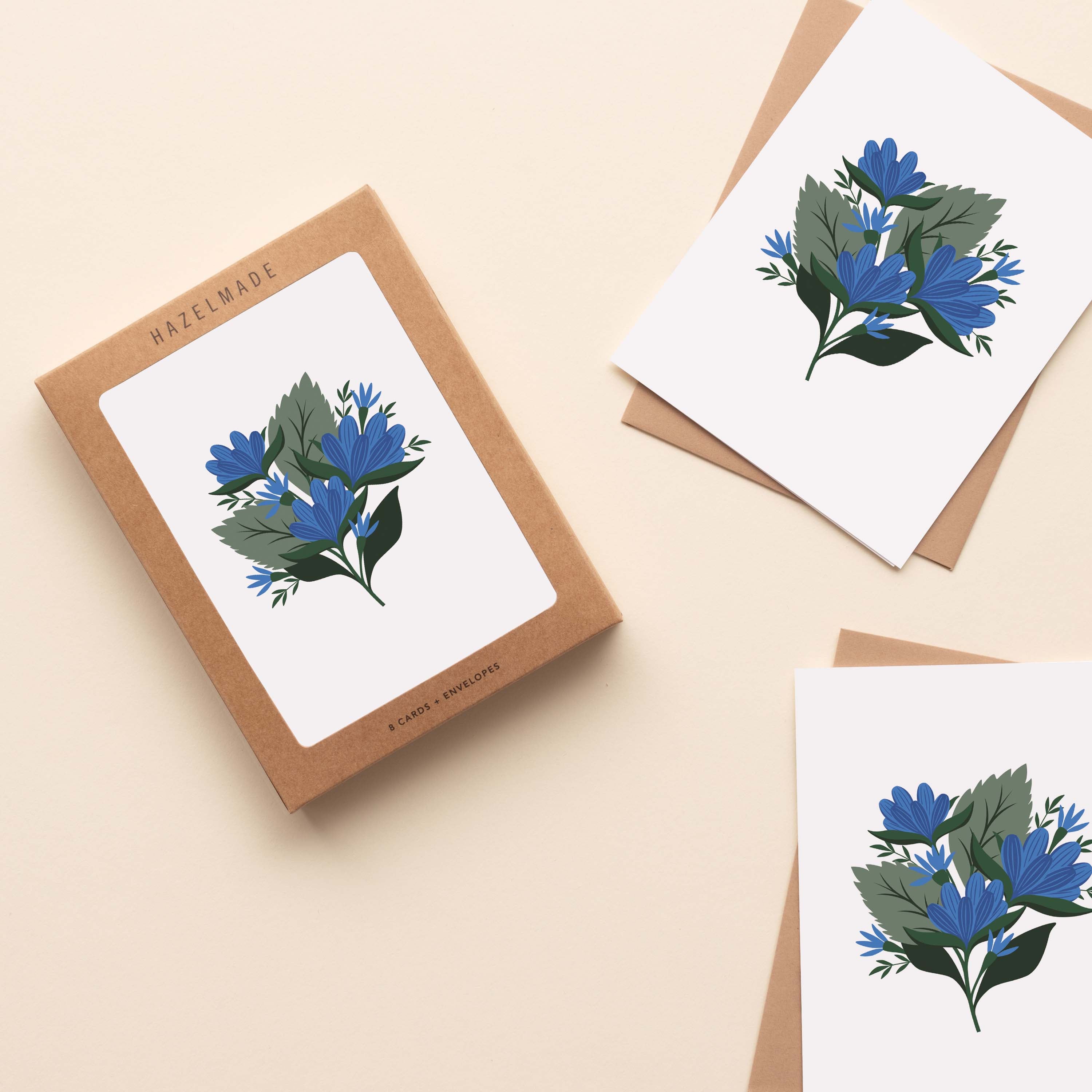 A boxed set of Blue Gentian Greeting Cards sitting with two cards and their envelopes featuring a hand-illustrated blue gentian flower design