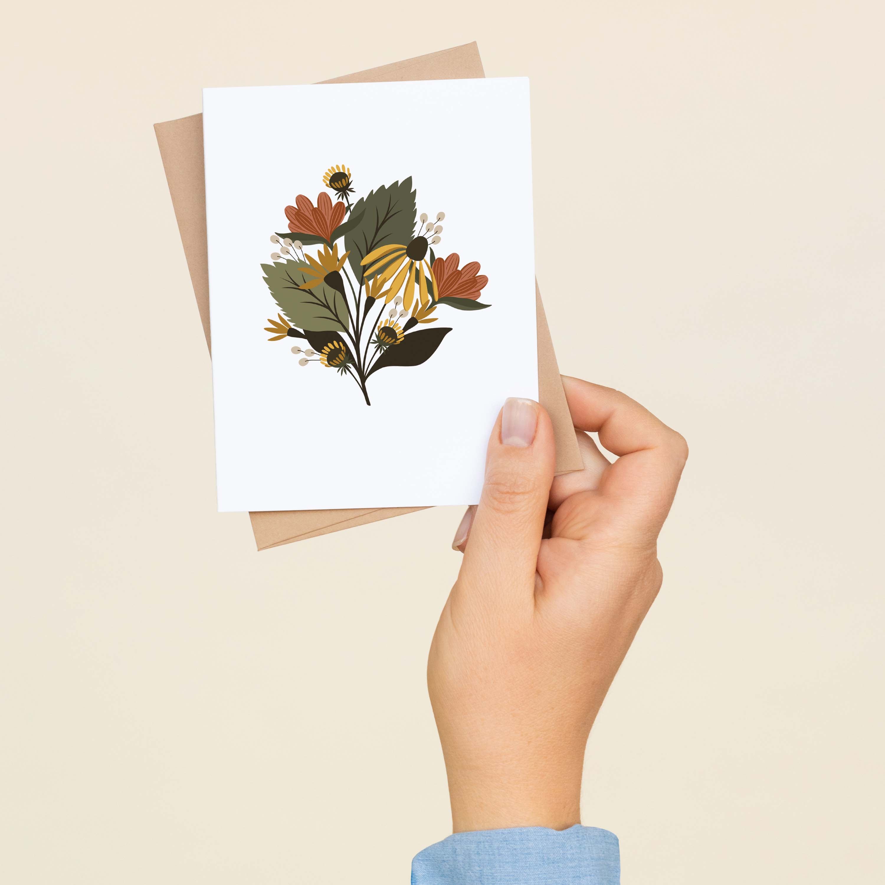 A hand holding a Fall Florals greeting card showing the hand-illustrated autumn floral design