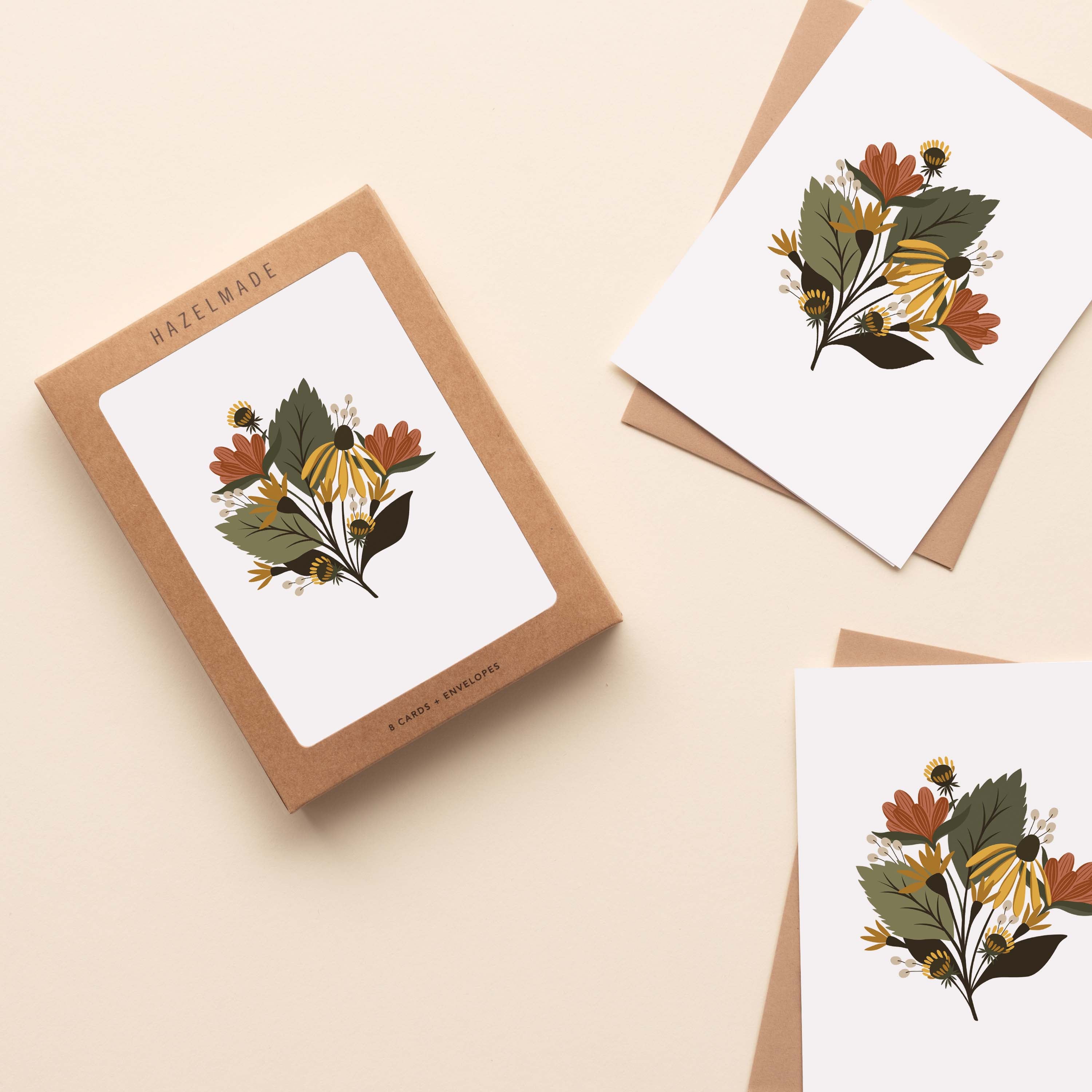A boxed set of Fall Florals Greeting Cards sitting with two cards and their envelopes featuring a hand-illustrated autumn floral design