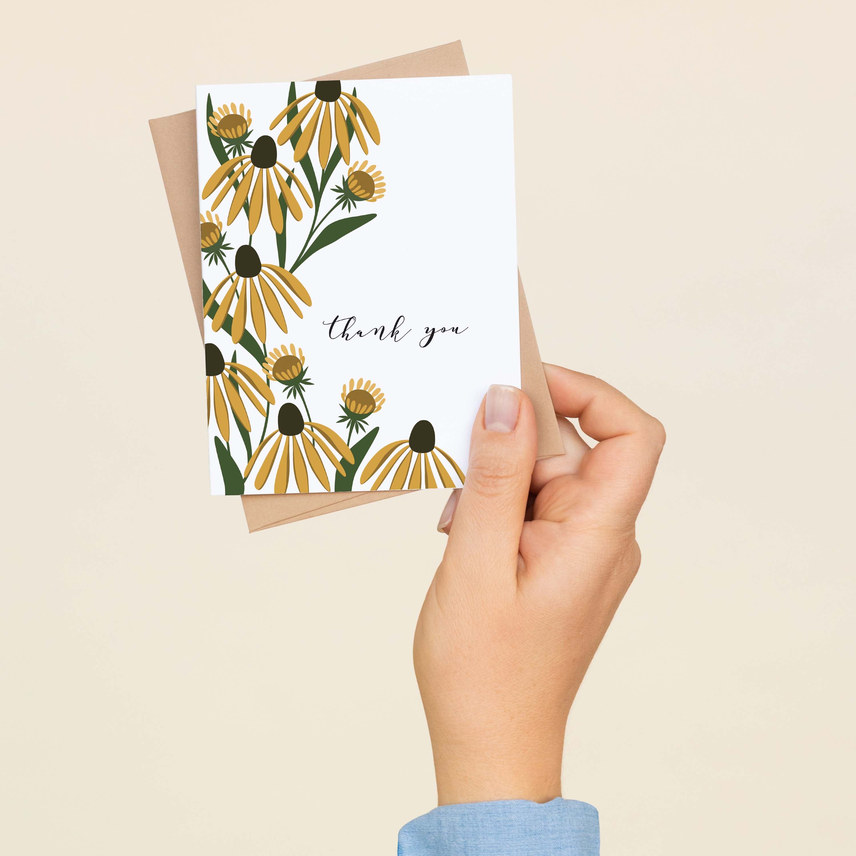 A hand holding a Golden Coneflower Thank You greeting card showing the hand-illustrated golden coneflower design