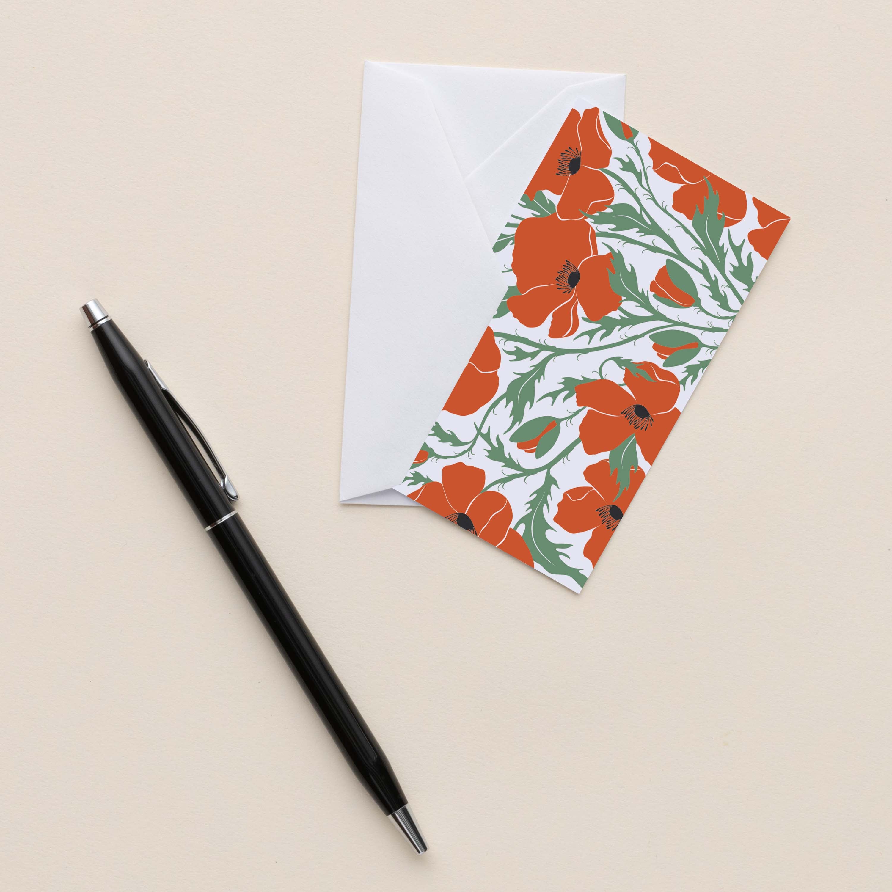 Poppies Mini Note Card with white envelope beside a black pen on a neutral background