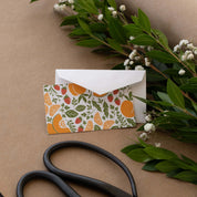 Farmstand Fruits Mini Note Card styled with a white envelope, greenery, and scissors on kraft paper