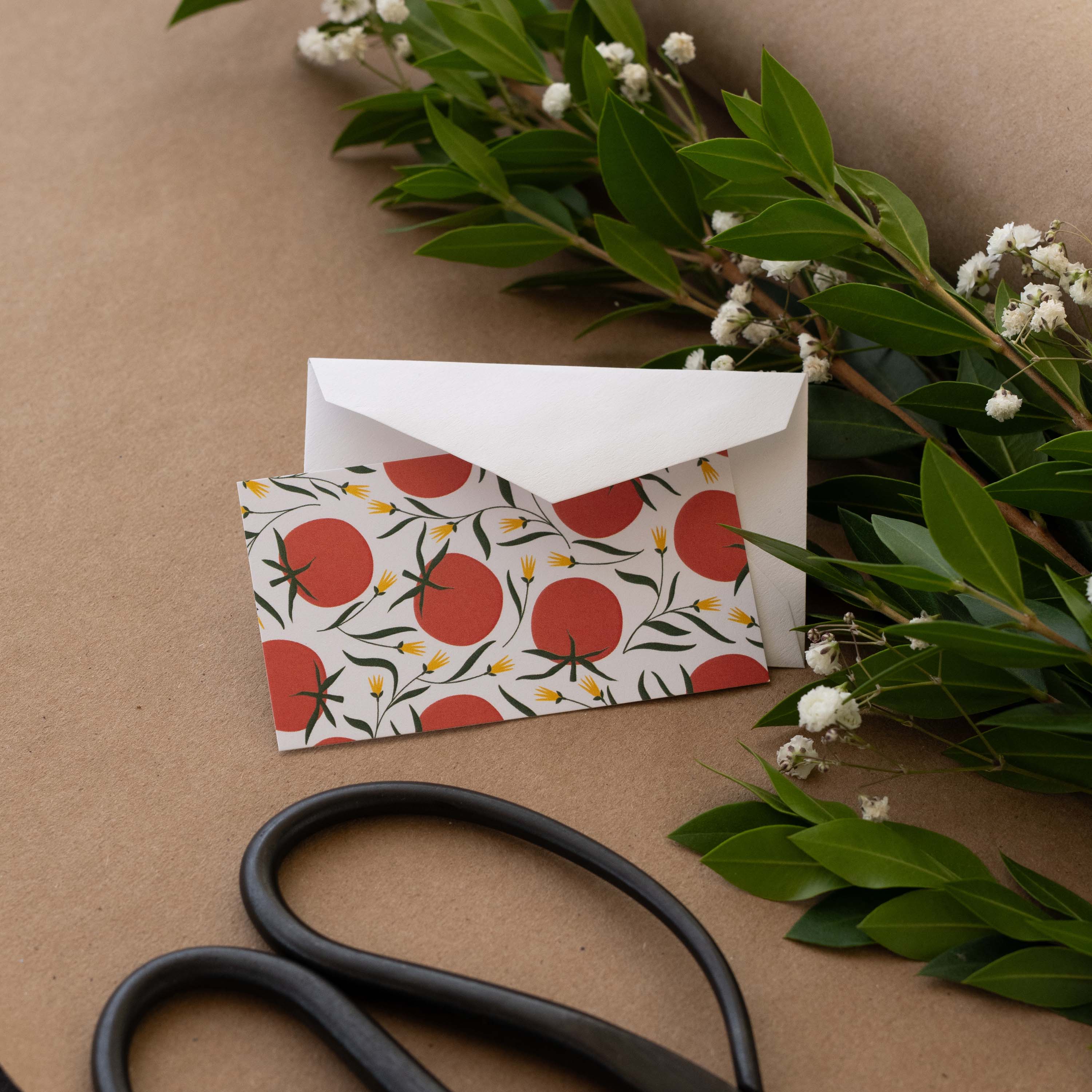 Tomatoes Mini Note Card styled with a white envelope, greenery, and scissors on kraft paper