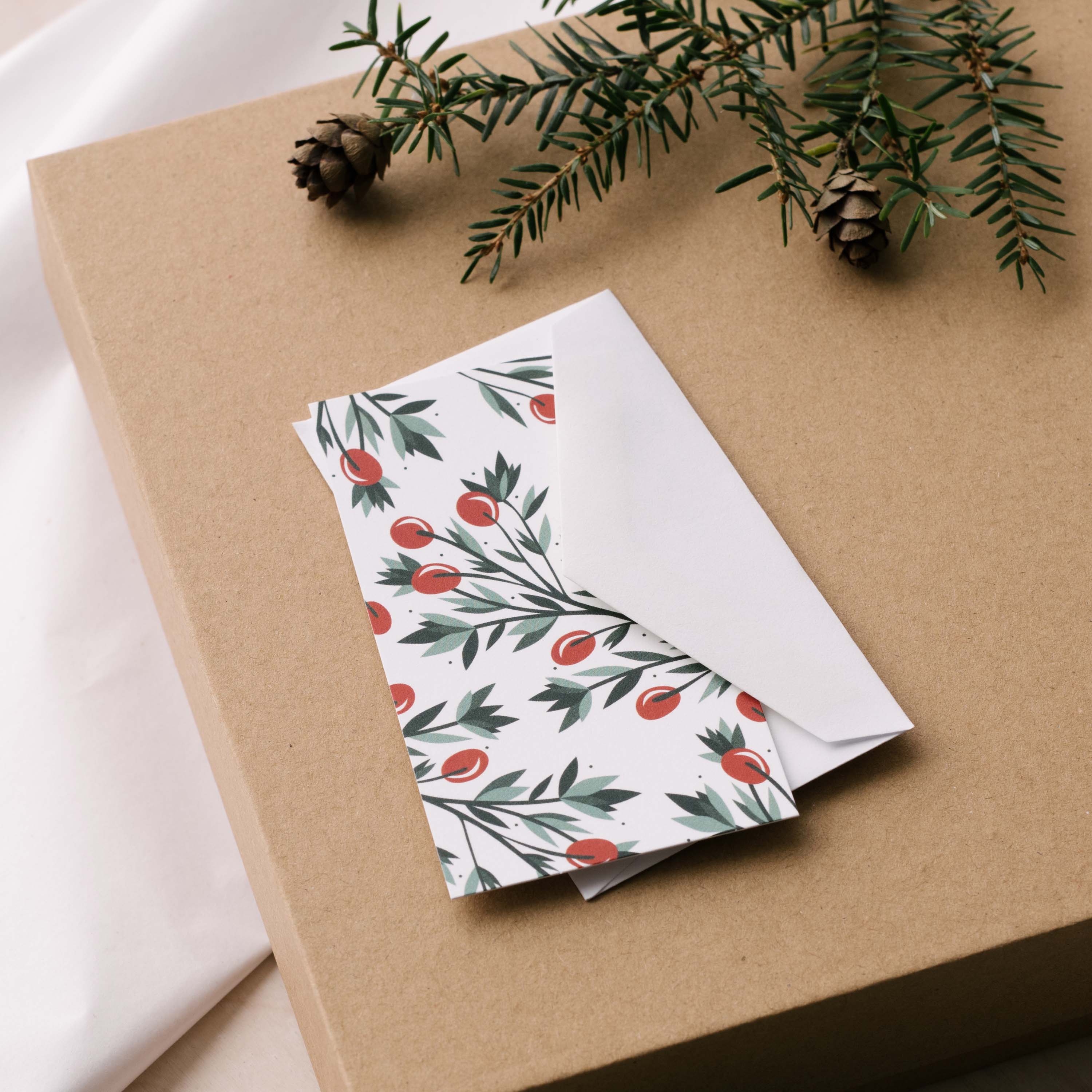 Holly Mini Note Card and white envelope sitting on a gift box with greenery