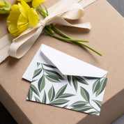 Aster Leaves Mini Note Card sitting on a wrapped gift box with ribbon and yellow flowers