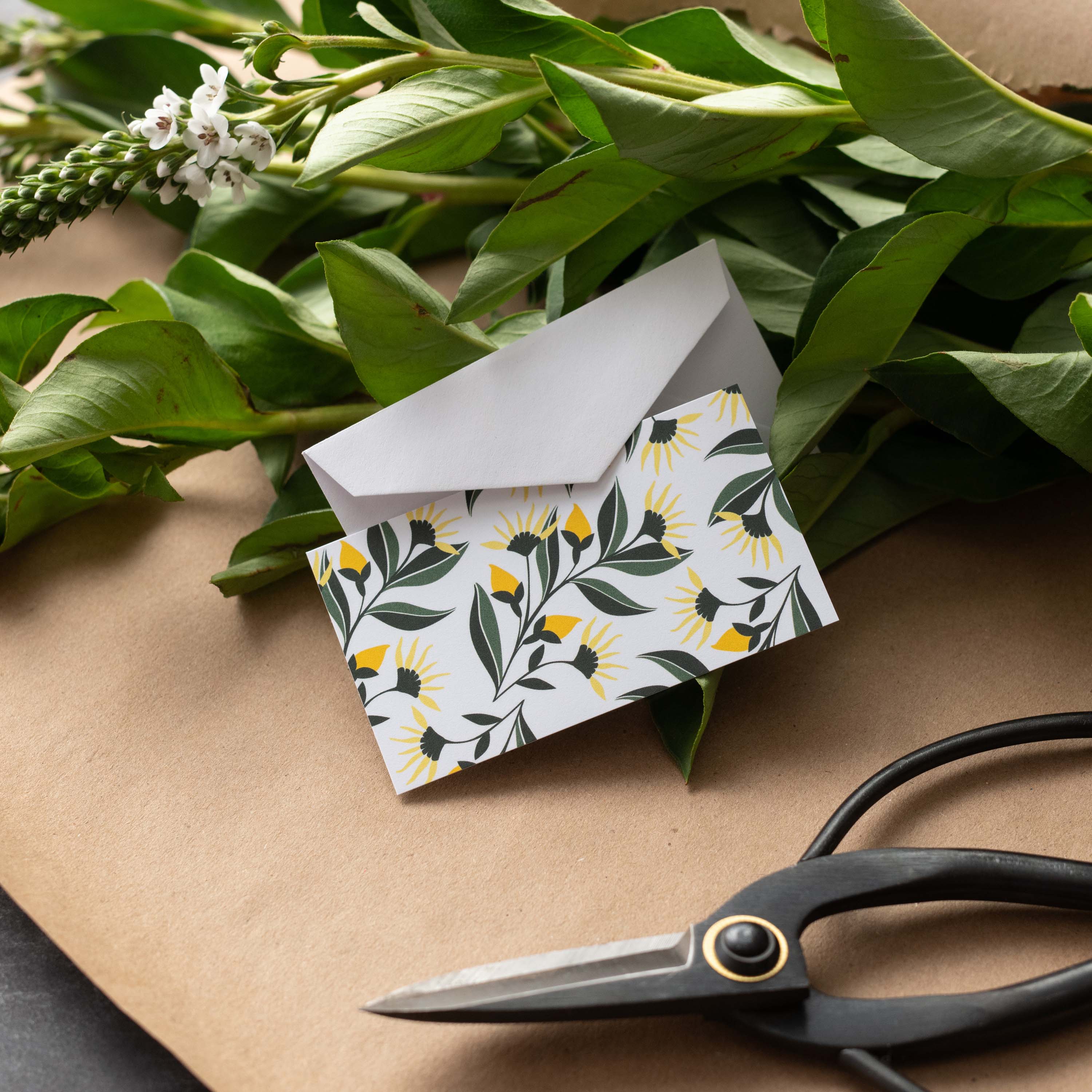 Aster Flowers Mini Note Card styled with a white envelope, greenery, and scissors on kraft paper