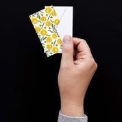 Hand holding a Marigold Mini Note Card with a white envelope against a dark background