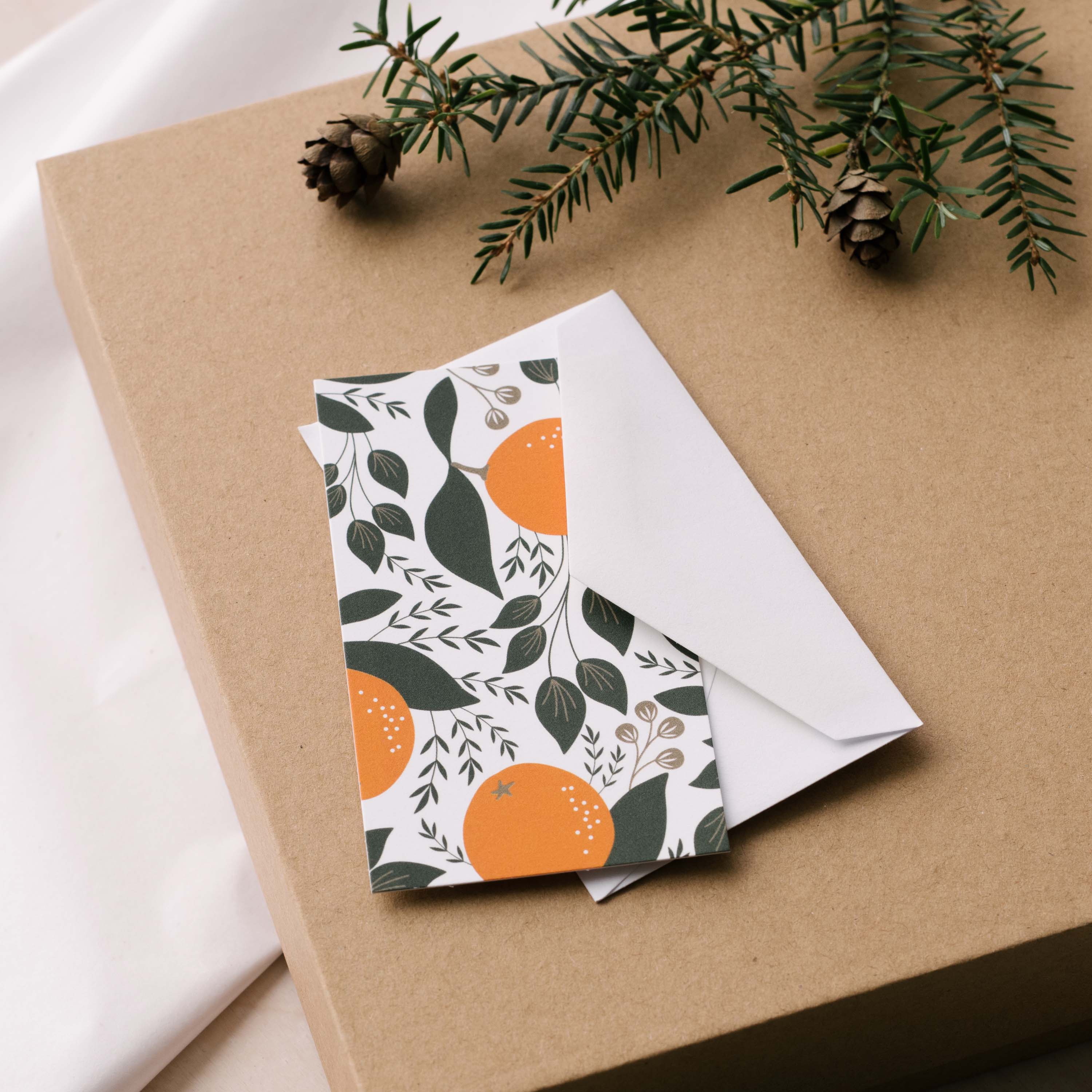 Winter Citrus Mini Note Card and white envelope sitting on a gift box with greenery