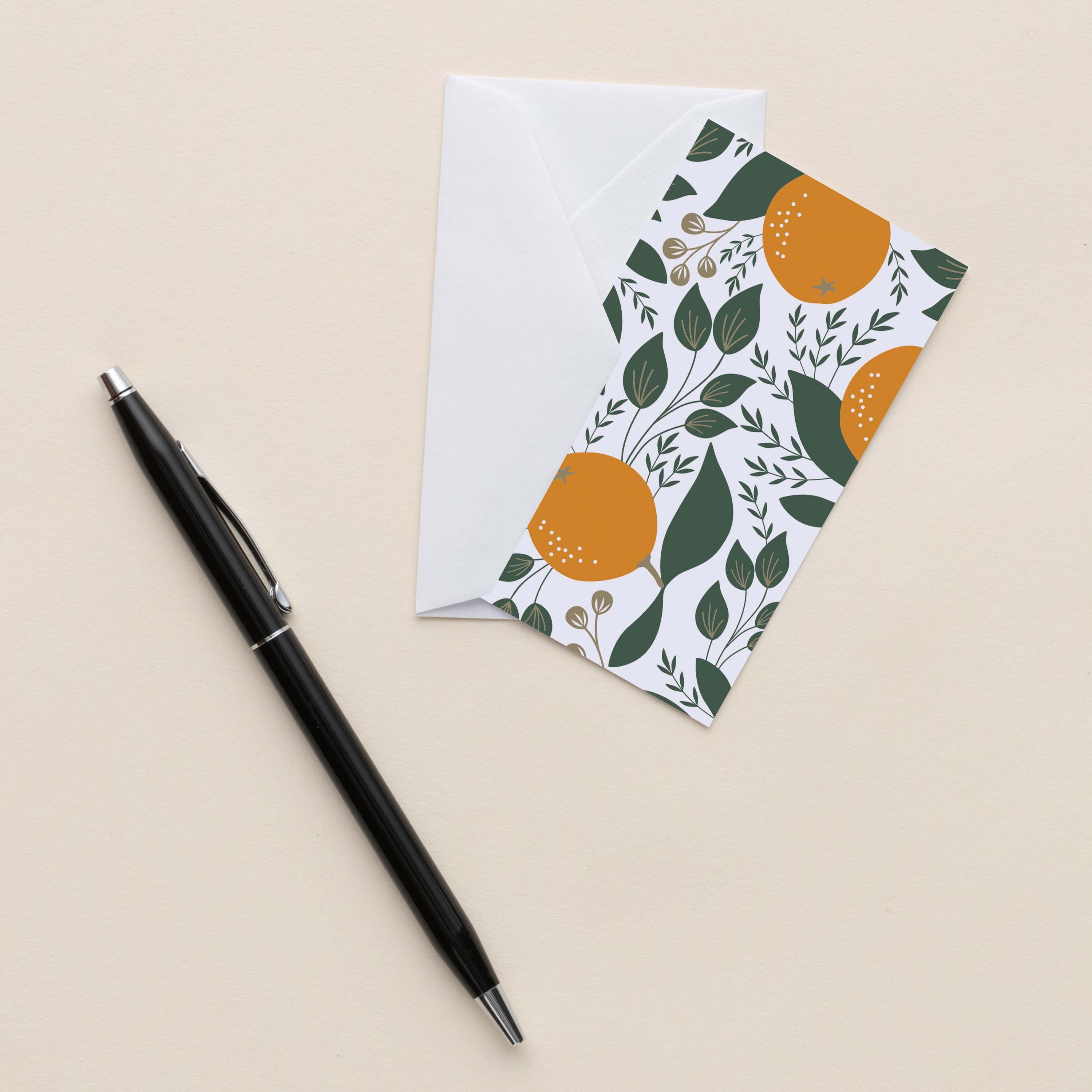 Winter Citrus Mini Note Card with white envelope beside a black pen on a neutral background
