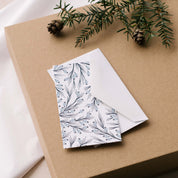 Winter Branch Mini Note Card and white envelope styled on a gift box with greenery