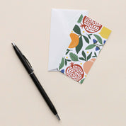 Fruit Basket Mini Note Card with white envelope beside a black pen on a neutral background