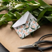 Tea Tin Bouquet Mini Note Card styled with a white envelope, greenery, and scissors on kraft paper