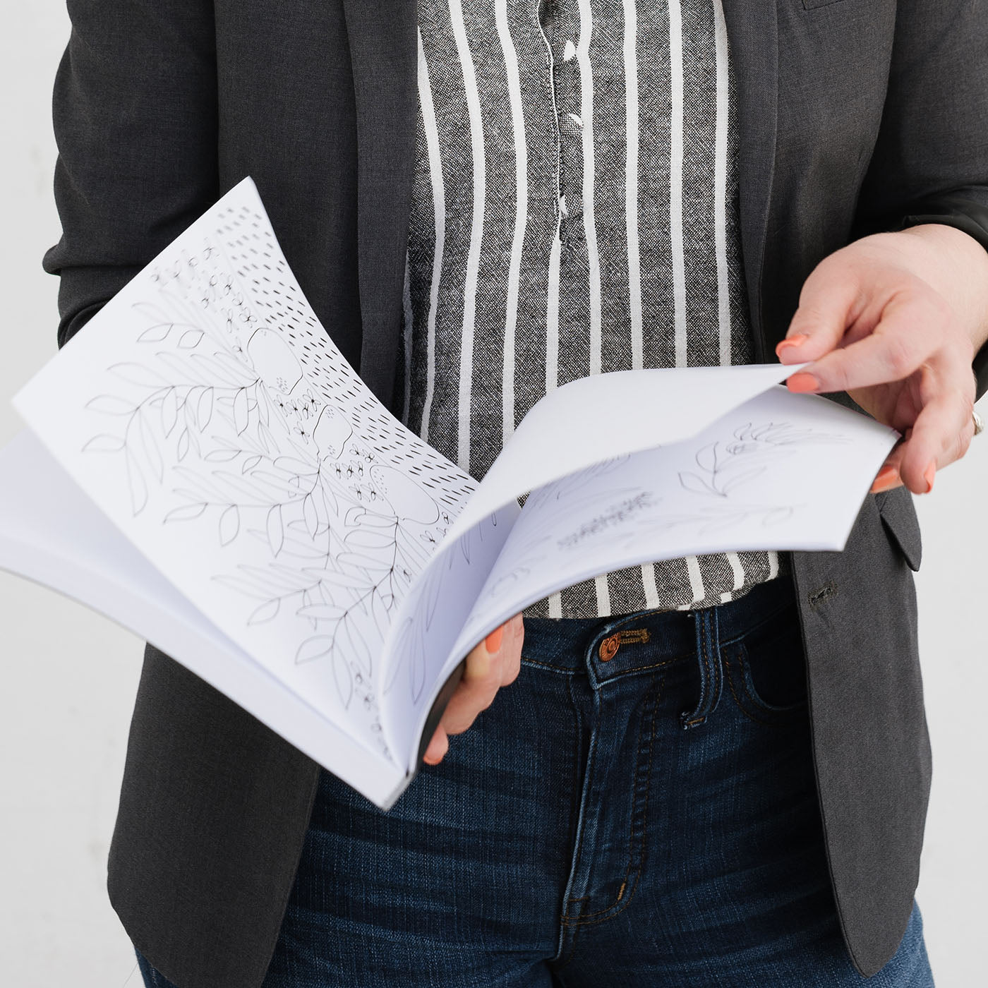 Susan Hazel Rich holding an open sketchbook with hand-drawn illustrations