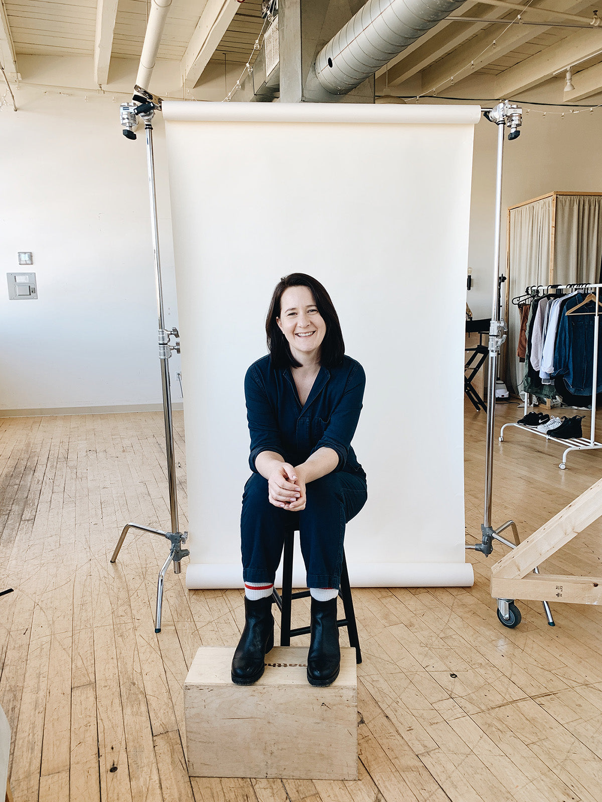 Portrait of Susan Hazel Rich seated in a studio with a photography backdrop