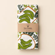 Folded Avocado Toast Tea Towel with wrap band and hand-illustrated avocado toast design