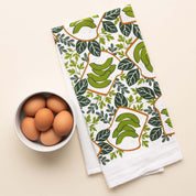 Avocado Toast Tea Towel with hand-illustrated avocado toast design beside a bowl of brown eggs