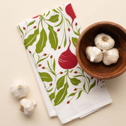 Beets Tea Towel with hand-illustrated beet design beside a wooden bowl of garlic