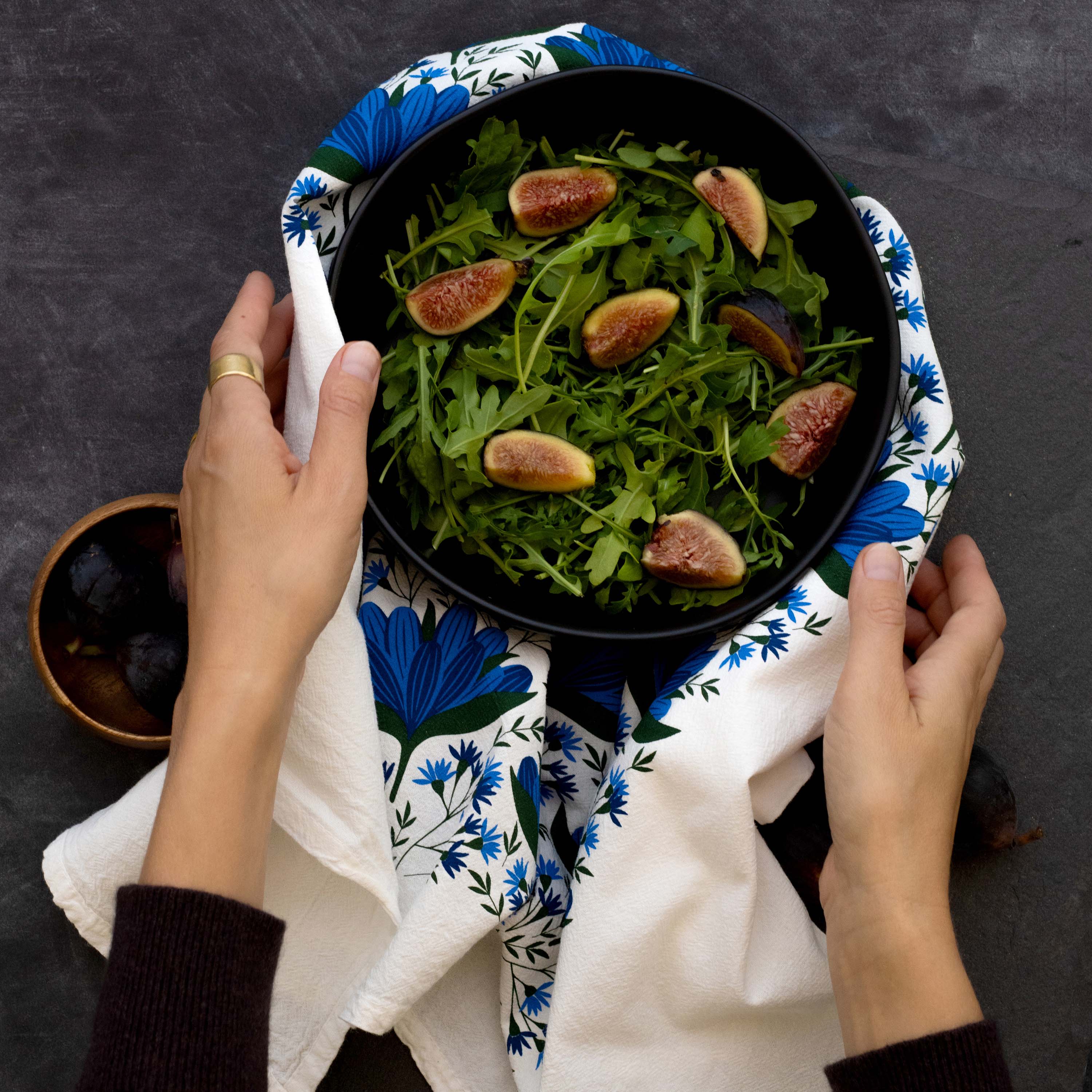 Blue Gentian Tea Towel wrapped around a bowl of salad held in both hands