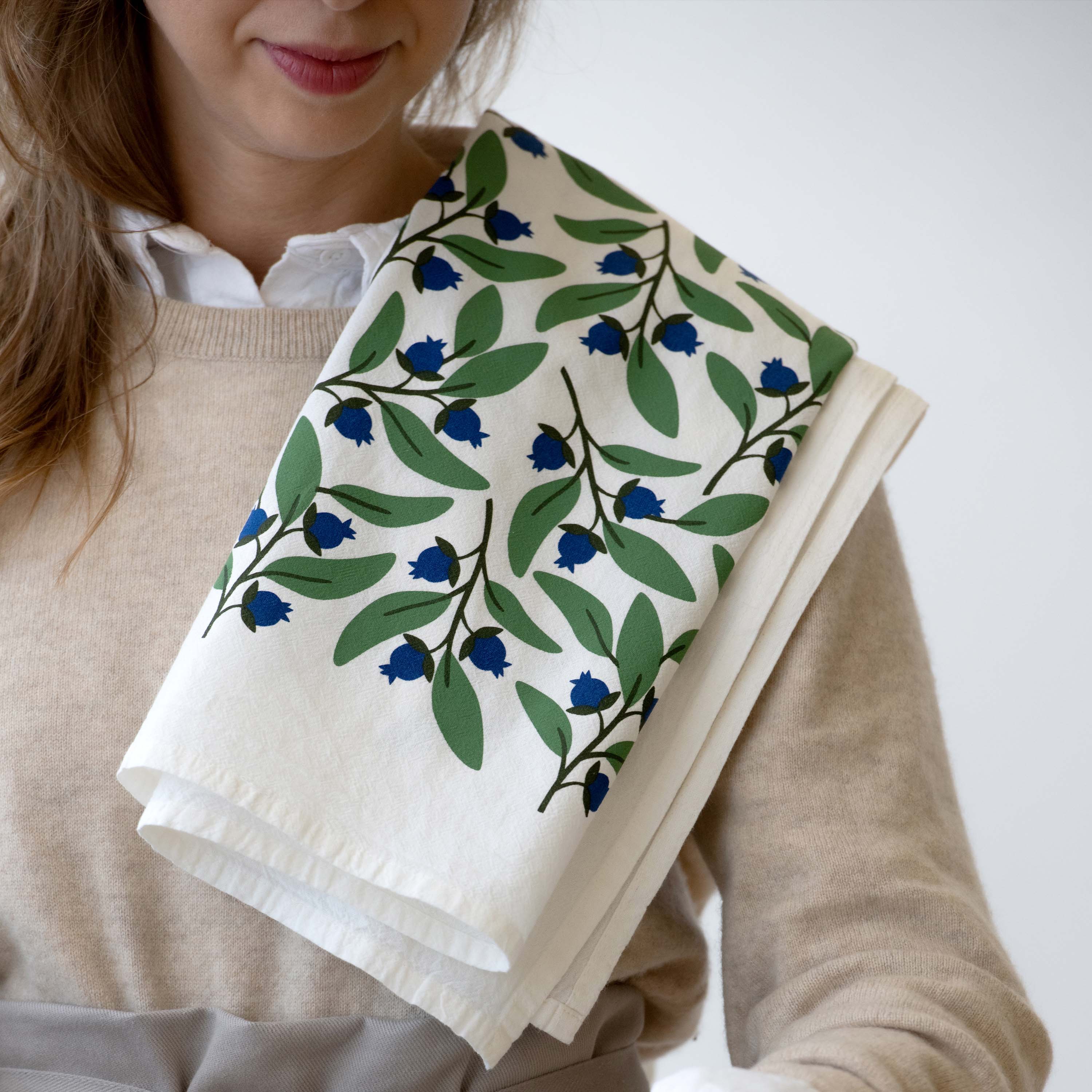 Blueberry Bushel Tea Towel draped over a person’s shoulder
