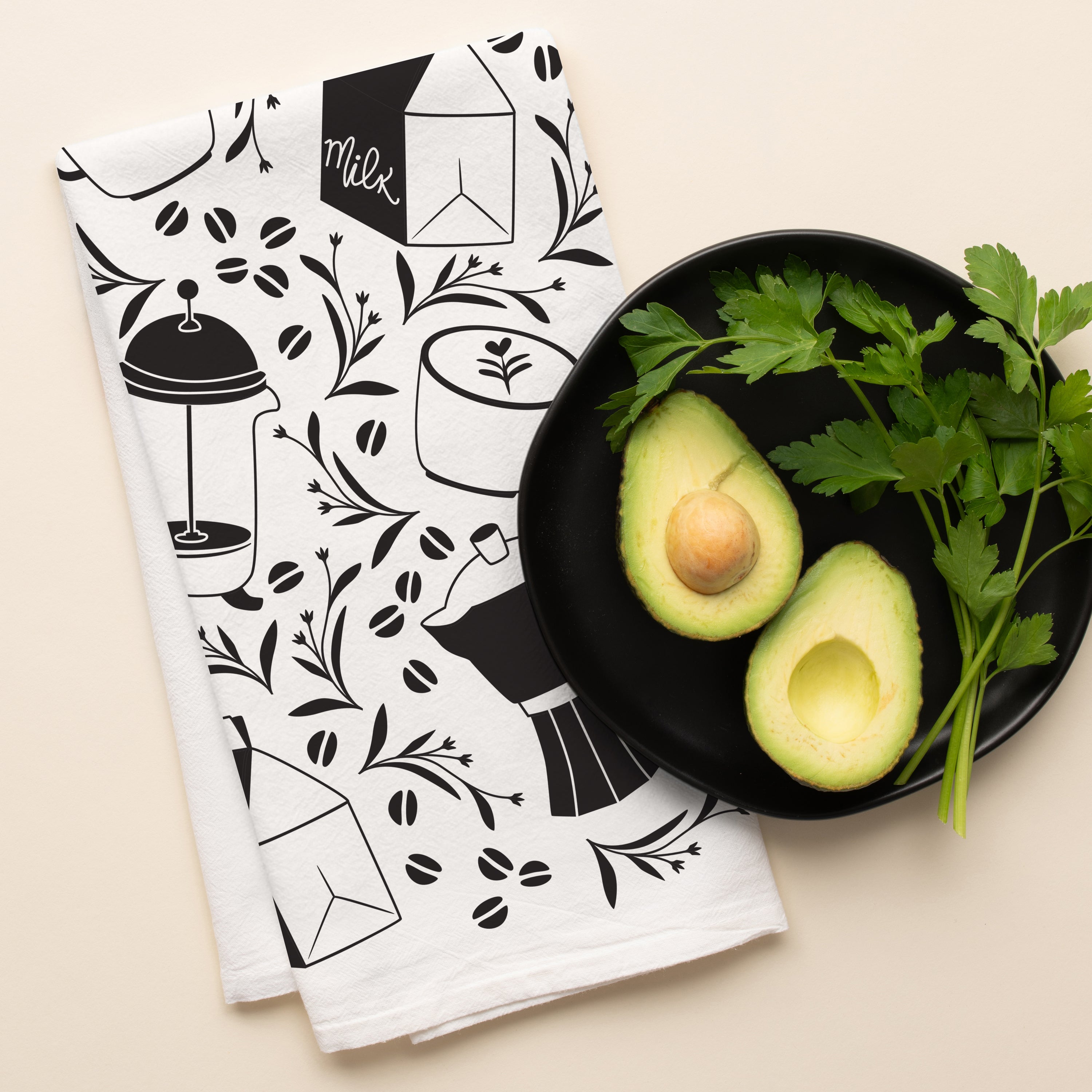 Coffee + Milk Tea Towel with hand-illustrated coffee and milk design beside a bowl of avocados and fresh herbs