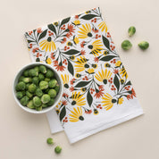 Fall Florals Tea Towel with hand-illustrated floral design beside a bowl of Brussels sprouts