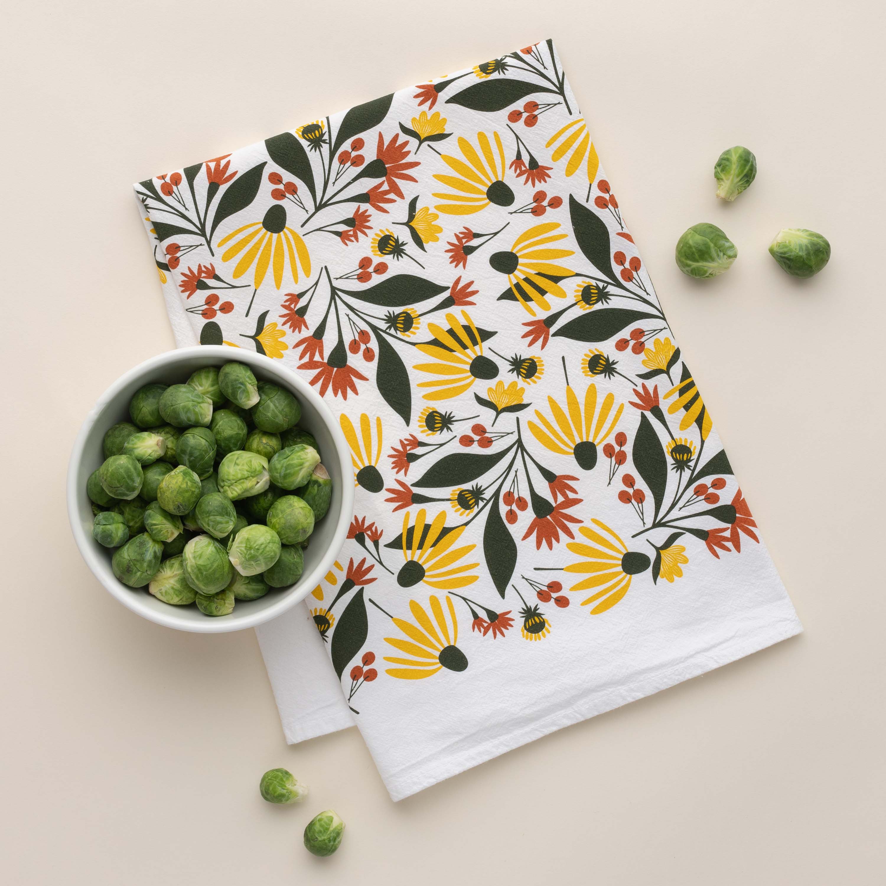 Fall Florals Tea Towel with hand-illustrated floral design beside a bowl of Brussels sprouts