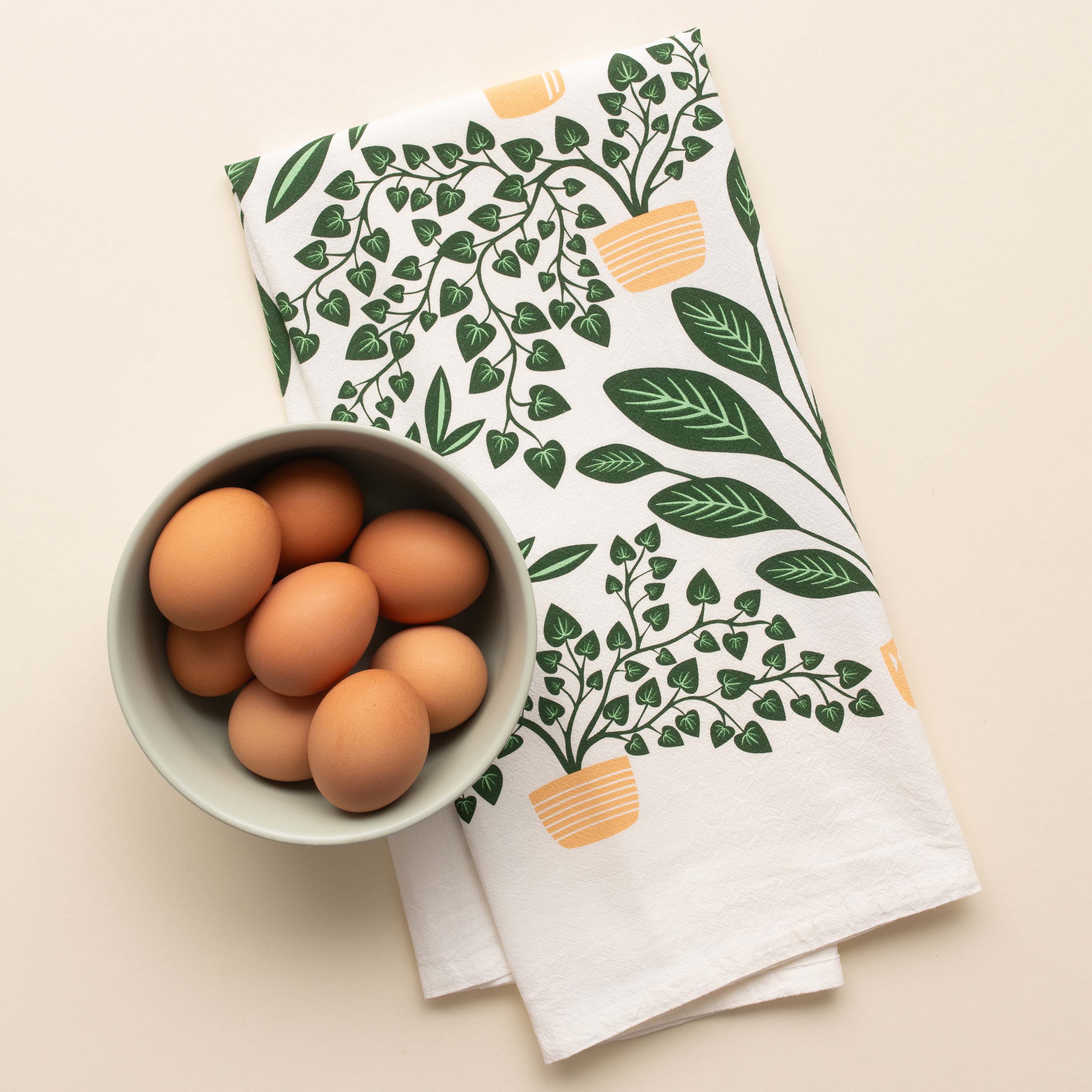 House Plants Tea Towel with hand-illustrated house plant design beside a bowl of brown eggs