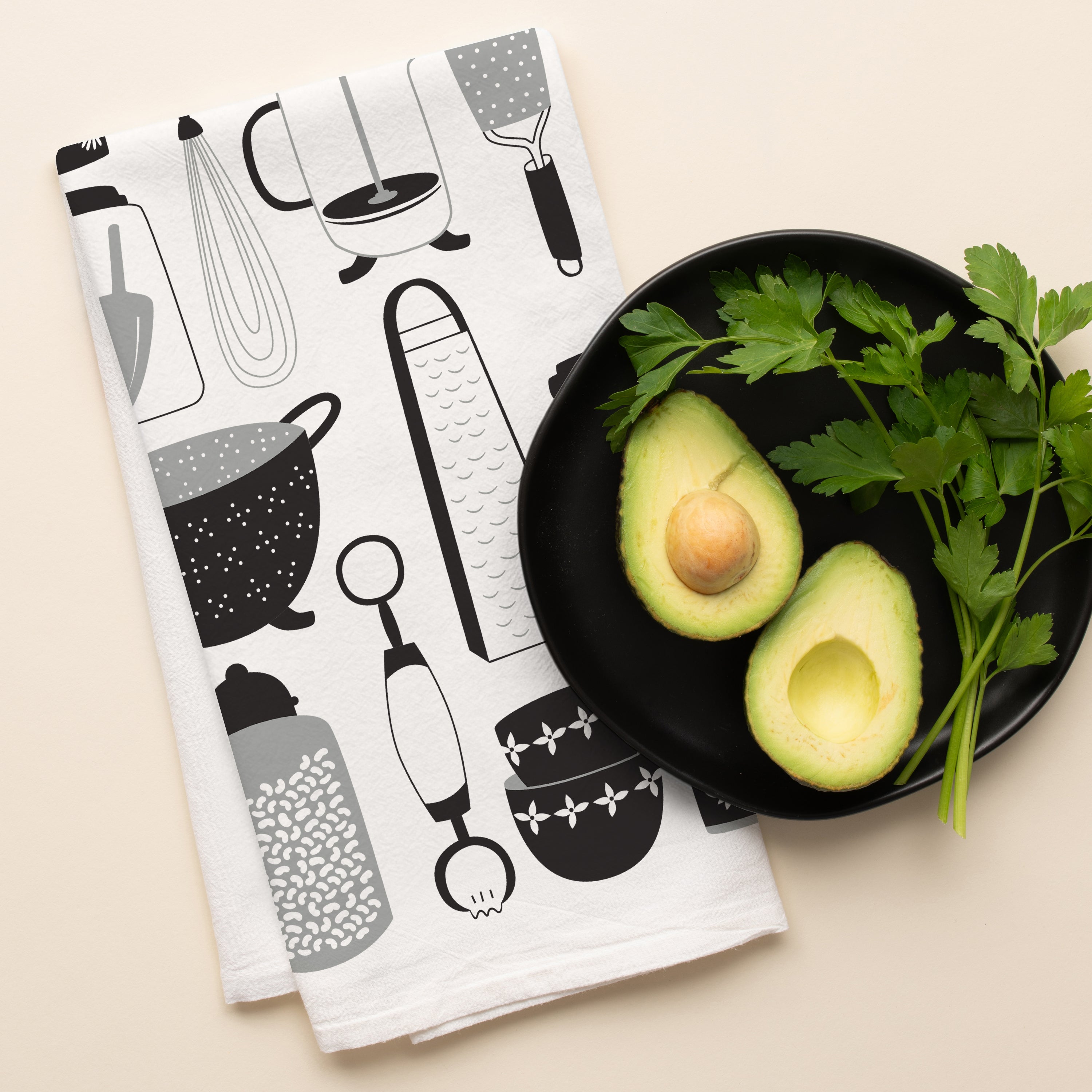 Kitchen Utensils Tea Towel with hand-illustrated kitchen utensil design beside halved avocados and parsley