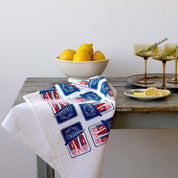 Sardines Tea Towel draped over a table beside lemons and drinks
