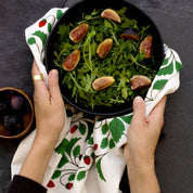 Wild Strawberries Tea Towel styled beneath a bowl of fig salad held by two hands
