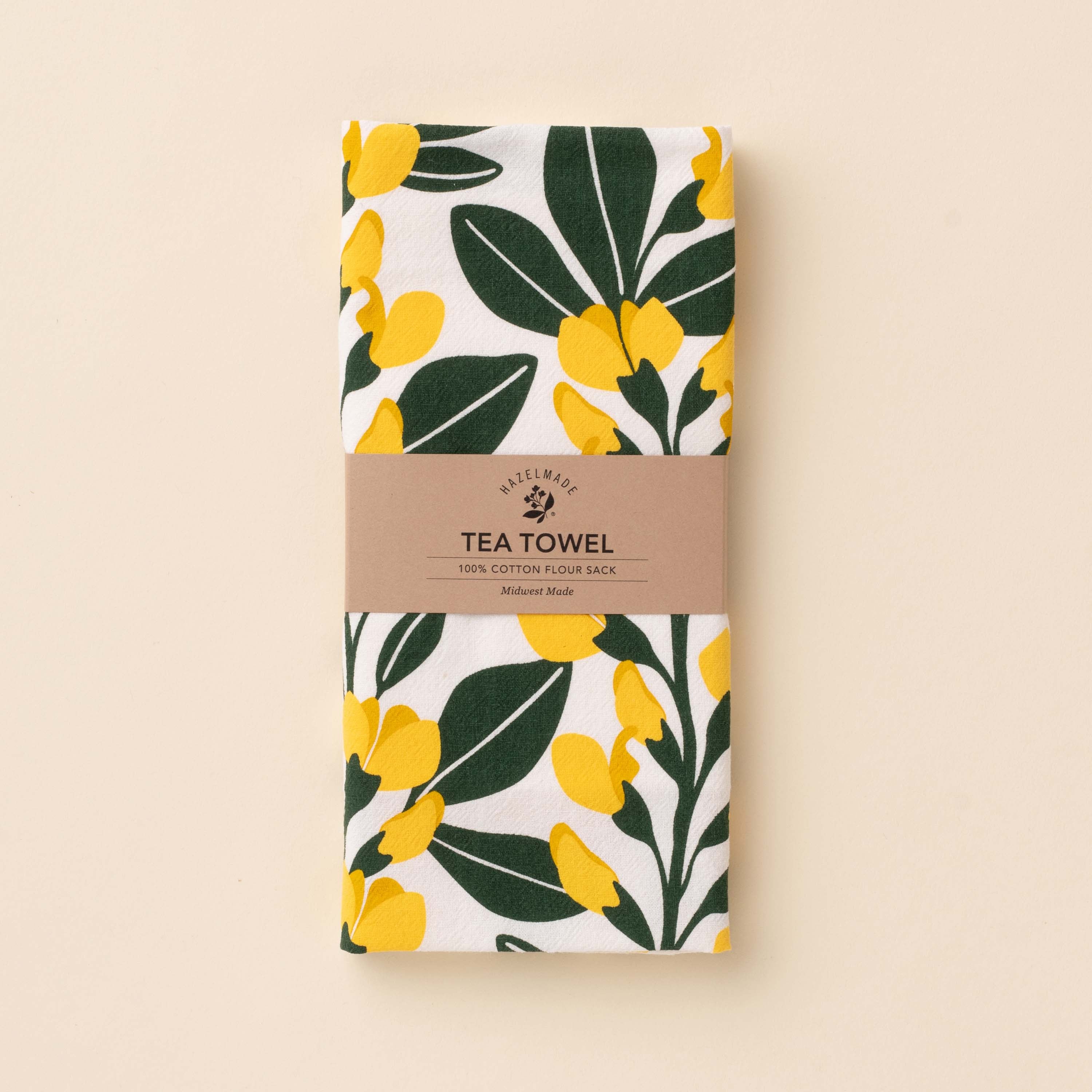 Folded Sundrops Tea Towel with wrap band and hand-illustrated yellow floral design