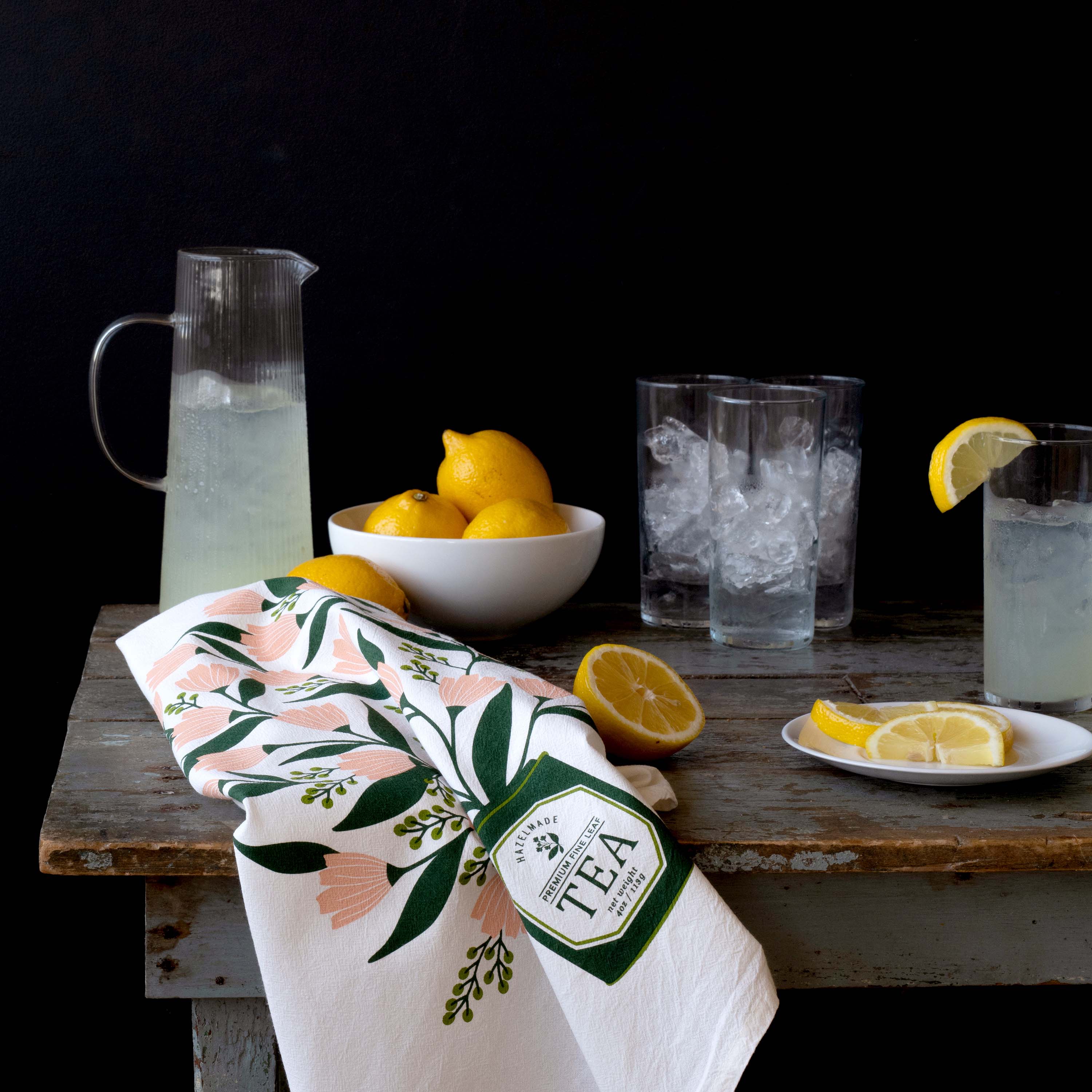 Tea Tin Bouquet Tea Towel draped over a table beside lemons, glasses, and a pitcher of lemonade