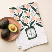 Tea Tin Bouquet Tea Towel with hand-illustrated floral tea tin design beside avocados on a plate