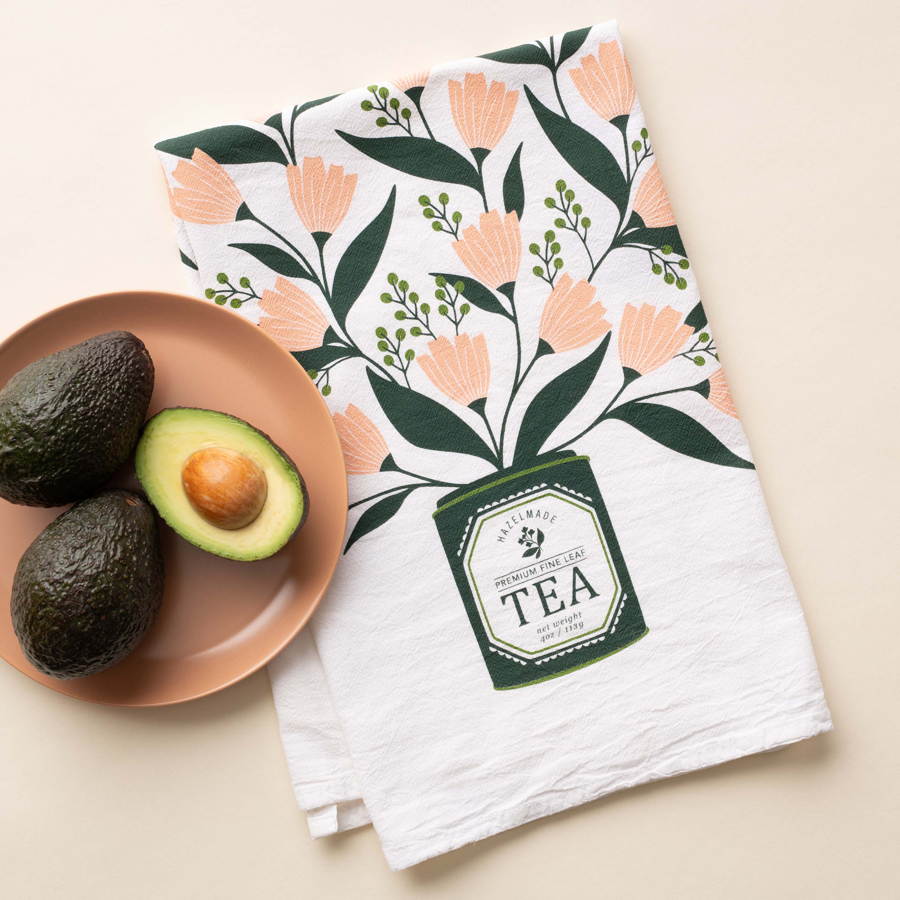 Tea Tin Bouquet Tea Towel with hand-illustrated floral tea tin design beside avocados on a plate