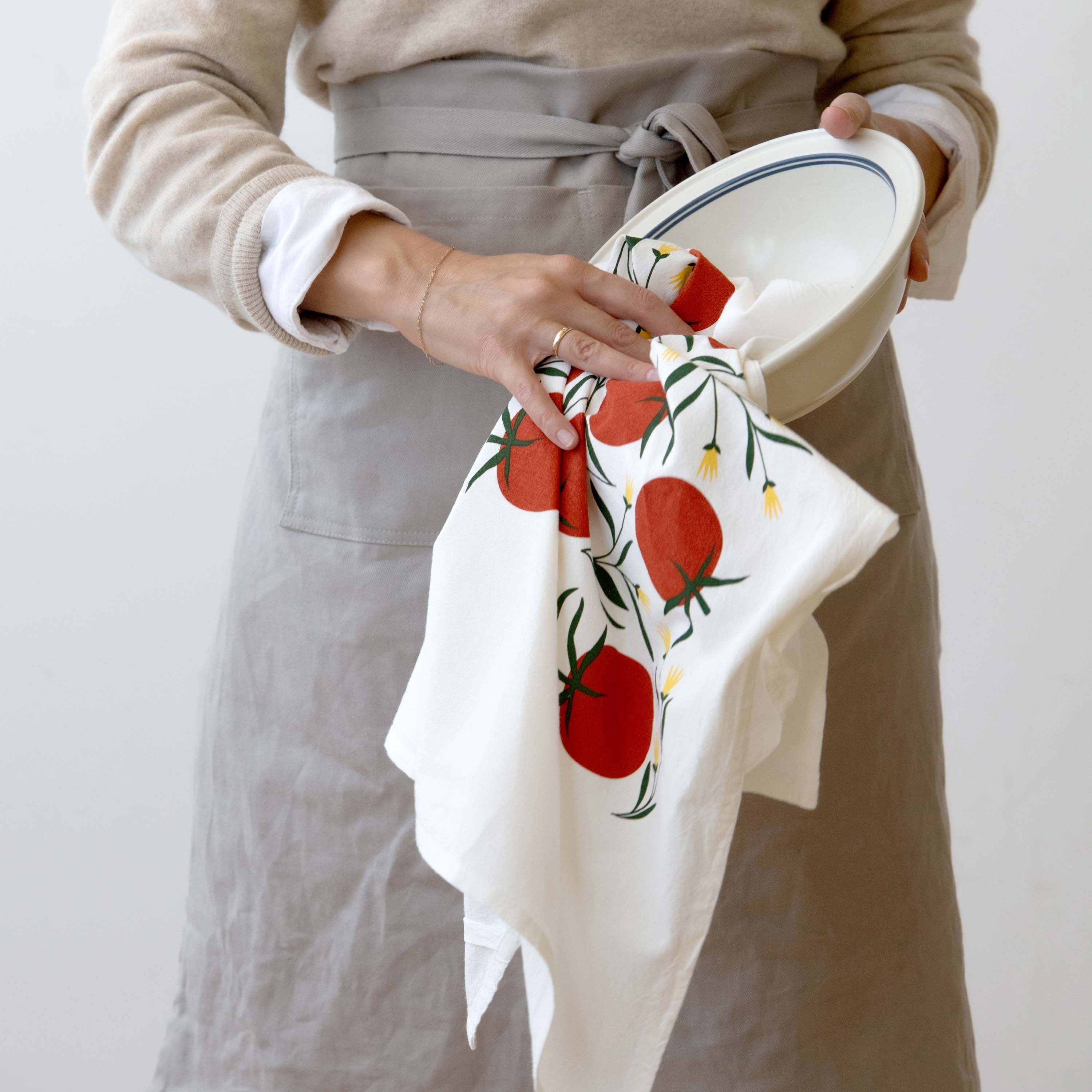 Tomatoes Tea Towel held by a person in a linen apron drying a bowl