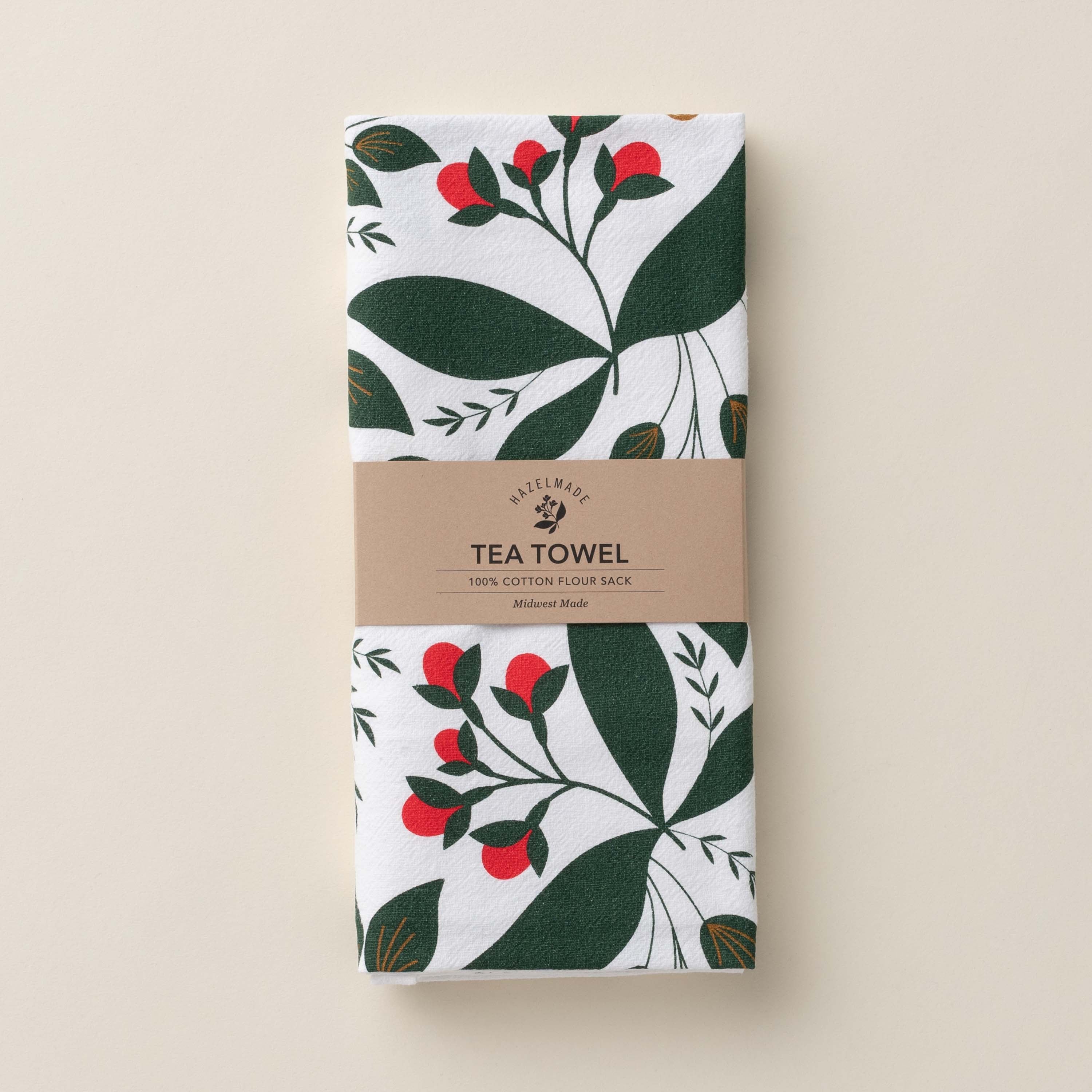 Folded Winterberry Tea Towel with wrap band and hand-illustrated winterberry design