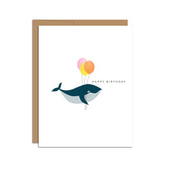 Single folded A2 greeting card with an envelope with an illustration of a whale holding three balloons. To the upper right of the whale is text that states "Happy Birthday."