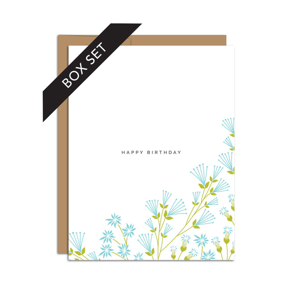 Box set of 8 folded A2 greeting cards with envelopes with an illustration of blue flowers wrapping the bottom and right side of the card. In the center, the text states "Happy Birthday".