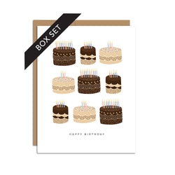 Box set of 8 folded A2 greeting cards with envelopes with an illustration of a grid of various brown and tan birthday cakes with colorful candles. Below the grid, the text states "Happy Birthday".