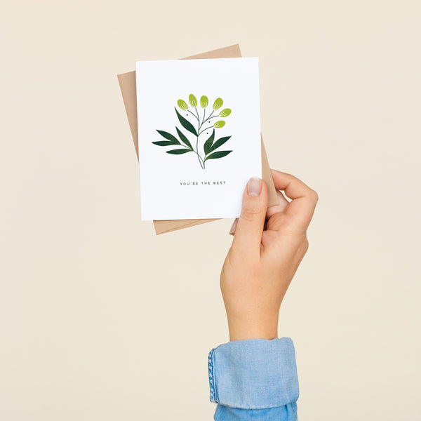 Single folded A2 greeting card with an envelope with an illustration of a green leaf in the center of the card and text below it that states "You're The Best".