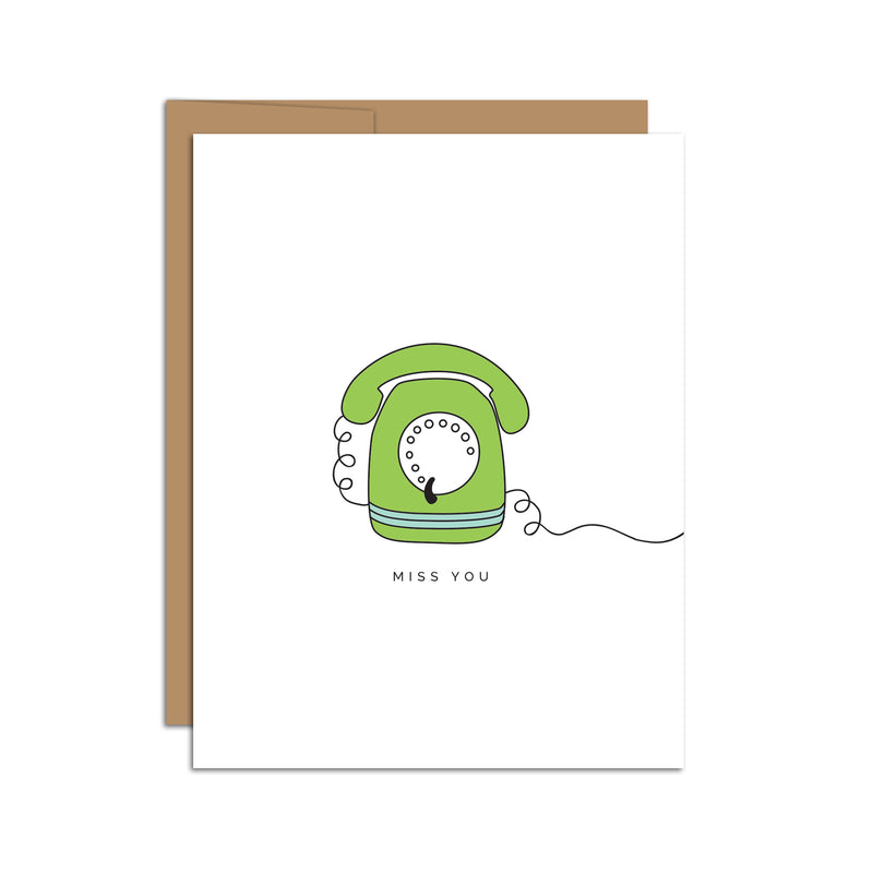 Single folded A2 greeting card with an envelope with an illustration of a green rotary dial phone and text below it that states "Miss You".