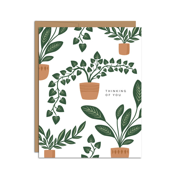 Single folded A2 greeting card with an envelope with an illustration of various potted plants and text that states "Thinking of You".